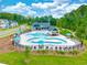 An aerial view of a community pool with a winding shape, surrounded by lounge chairs and lush landscaping at 232 Berry Mill Ln # 201, Raleigh, NC 27603