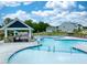 A stunning pool with a beach-style entry, surrounded by lounge chairs, umbrellas, and lush landscaping at 232 Berry Mill Ln # 201, Raleigh, NC 27603