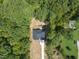 High angle aerial view of home showing roof and driveway situated amongst mature tree providing nice privacy at 242 Sequoia Dr, Louisburg, NC 27549