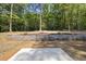 Landscaped backyard with retaining wall and concrete patio at 242 Sequoia Dr, Louisburg, NC 27549