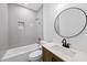 Well-lit full bathroom with grey tiling, dark wood vanity, and bronze fixtures at 242 Sequoia Dr, Louisburg, NC 27549