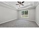 Spacious bedroom features tray ceiling, neutral carpet, and a view of the backyard at 242 Sequoia Dr, Louisburg, NC 27549
