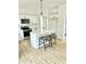 Modern kitchen features an island with seating, white cabinets and a stainless steel stove at 242 Sequoia Dr, Louisburg, NC 27549