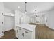 Bright, open-concept living space boasts a kitchen island, sleek floors, and a cozy fireplace at 242 Sequoia Dr, Louisburg, NC 27549