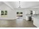 Open floor plan living room area features modern floors, natural light, and kitchen with stainless appliances at 242 Sequoia Dr, Louisburg, NC 27549