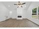 Well-lit living room showcases a fireplace, large windows, and a modern ceiling fan at 242 Sequoia Dr, Louisburg, NC 27549