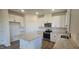 Beautiful kitchen with white cabinets, island with granite countertops and stainless steel appliances at 466 Saint Clair Dr, Fuquay Varina, NC 27526