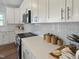 Close-up of a modern kitchen with white cabinets, countertops, and herringbone backsplash at 120 Whistling Way # Cary Traditiol, Lillington, NC 27546