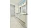 Bathroom showcasing a dual sink vanity and neutral tile flooring with a walk-in closet visible in the background at 2048 Abbeyhill Dr # 98, Raleigh, NC 27610