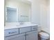 Bright bathroom featuring a gray vanity with white countertops and a large mirror at 809 St Charles St, Durham, NC 27713