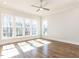 Bright bedroom featuring hardwood floors, a ceiling fan, and an abundance of natural light from large windows at 809 St Charles St, Durham, NC 27713