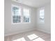 Sun-filled bedroom with neutral carpet, multiple windows offering abundant natural light, and fresh paint at 809 St Charles St, Durham, NC 27713