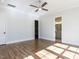Well-lit bedroom with hardwood floors, a ceiling fan, and doorways leading to a walk-in closet and bathroom at 809 St Charles St, Durham, NC 27713