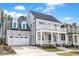 Charming two-story home with a welcoming front porch and balcony, complemented by lush landscaping at 809 St Charles St, Durham, NC 27713