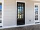 Close up view of a craftsman-style front door with glass panels and sidelights at 809 St Charles St, Durham, NC 27713