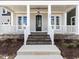 Inviting front porch with brick stairs, white railings, and craftsman style door at 809 St Charles St, Durham, NC 27713