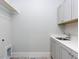 Functional laundry area features a utility sink with storage cabinets and space for a washer and dryer at 809 St Charles St, Durham, NC 27713