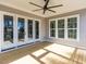 Covered porch featuring french doors, a ceiling fan, and natural wood flooring at 809 St Charles St, Durham, NC 27713