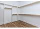 Spacious walk-in closet with built-in shelving and wooden rods for optimal storage and organization at 809 St Charles St, Durham, NC 27713