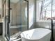 Modern bathroom showcasing a glass-enclosed shower and a standalone soaking tub near a bright window at 30 Tamaran Ct, Spring Hope, NC 27882