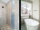 Bright bathroom featuring a tiled glass shower and a standalone soaking tub near a bright window at 30 Tamaran Ct, Spring Hope, NC 27882