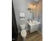 This bathroom features a framed painting and a toilet with an adjacent sink and cabinet at 1000 Azalea Garden Circle, Raleigh, NC 27603
