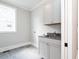 Practical laundry room with white cabinets, ample counter space, and modern fixtures at 1000 Azalea Garden Circle, Raleigh, NC 27603