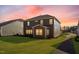 Exterior of a two-story home featuring a green lawn, dark siding, and a sidewalk at 736 Heathered Farm Way, Apex, NC 27523