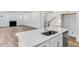 Open kitchen with stainless sink, granite countertops, and view to the living room at 736 Heathered Farm Way, Apex, NC 27523