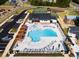 Aerial view of a community pool with lounge chairs, umbrellas, pergolas, clubhouse, and tennis courts at 736 Heathered Farm Way, Apex, NC 27523