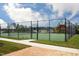 Well-maintained community tennis court featuring a green surface and surrounded by a secure fence and lush landscaping at 736 Heathered Farm Way, Apex, NC 27523
