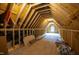 Unfinished attic with wooden beams, OSB flooring, and a window, ready for customization at 1000 Marilyn Dr, Raleigh, NC 27607
