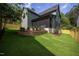 Spacious backyard with a lush green lawn, brick retaining wall, and a screened-in porch at 1000 Marilyn Dr, Raleigh, NC 27607
