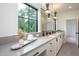 Modern bathroom featuring a long vanity with double sinks, decorative lighting, and a large window with a view at 1000 Marilyn Dr, Raleigh, NC 27607
