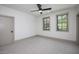 Inviting bedroom features soft carpeting, neutral paint, ceiling fan, and two windows with outdoor views at 1000 Marilyn Dr, Raleigh, NC 27607