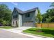 Exterior side view highlighting green siding, a two-car garage, and lush landscaping with a well-kept lawn at 1000 Marilyn Dr, Raleigh, NC 27607