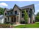 Elegant two-story home featuring a brick facade, manicured lawn, and stylish architectural details at 1000 Marilyn Dr, Raleigh, NC 27607