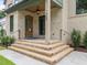 Inviting brick front entrance with an arched wood door, brick steps, black railing, and decorative light fixture at 1000 Marilyn Dr, Raleigh, NC 27607