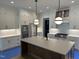 Spacious kitchen island featuring stainless steel appliances, white cabinets and modern light pendants at 1000 Marilyn Dr, Raleigh, NC 27607