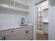Bright laundry room with white cabinetry, quartz countertops, undermount sink, and a closet at 1000 Marilyn Dr, Raleigh, NC 27607