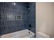 Modern shower area showcasing blue, vertically stacked tiling, white tub, and contemporary fixtures at 1000 Marilyn Dr, Raleigh, NC 27607