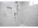 Shower with white and gold marble tiling, built-in shelves, and dual shower heads at 1000 Marilyn Dr, Raleigh, NC 27607