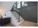 Staircase with black iron balusters and oak treads, next to a cabinet and decor at 1000 Marilyn Dr, Raleigh, NC 27607