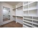 Spacious walk-in closet with custom shelving, hanging rods, and a full length mirror at 1000 Marilyn Dr, Raleigh, NC 27607