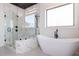 An elegant bathroom boasts a freestanding tub and glass-enclosed shower with luxurious finishes at 155 Gaines Trl, Pittsboro, NC 27312