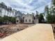Beautiful home with a long concrete driveway leading to an attached garage, surrounded by lush trees at 155 Gaines Trl, Pittsboro, NC 27312
