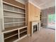 Living room detail showcasing built-in shelving, a fireplace, and access to the outside porch at 155 Gaines Trl, Pittsboro, NC 27312