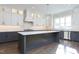 Modern kitchen featuring a large center island, stainless steel appliances, and stylish pendant lighting at 155 Gaines Trl, Pittsboro, NC 27312