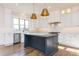 The modern kitchen offers stainless appliances, an island, and pendant lighting at 155 Gaines Trl, Pittsboro, NC 27312