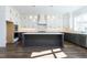 Spacious kitchen with white cabinets, grey island, stainless steel appliances, and contemporary lighting at 155 Gaines Trl, Pittsboro, NC 27312